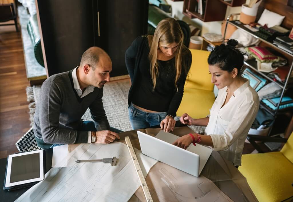 employees collaborating while looking at a computer