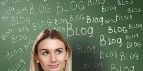 woman standing in front of chalkboard with blog written