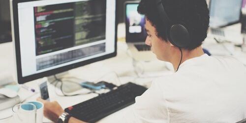 Front end web developer writing code at his computer.