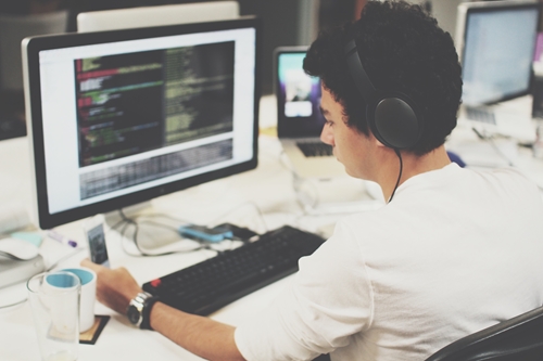 Front end web developer writing code at his computer.