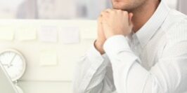 man looking off into the distance at his desk