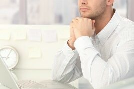 man looking off into the distance at his desk