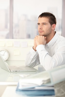man looking off into the distance at his desk