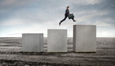 man jumping up large cement blocks in the middle of nowhere