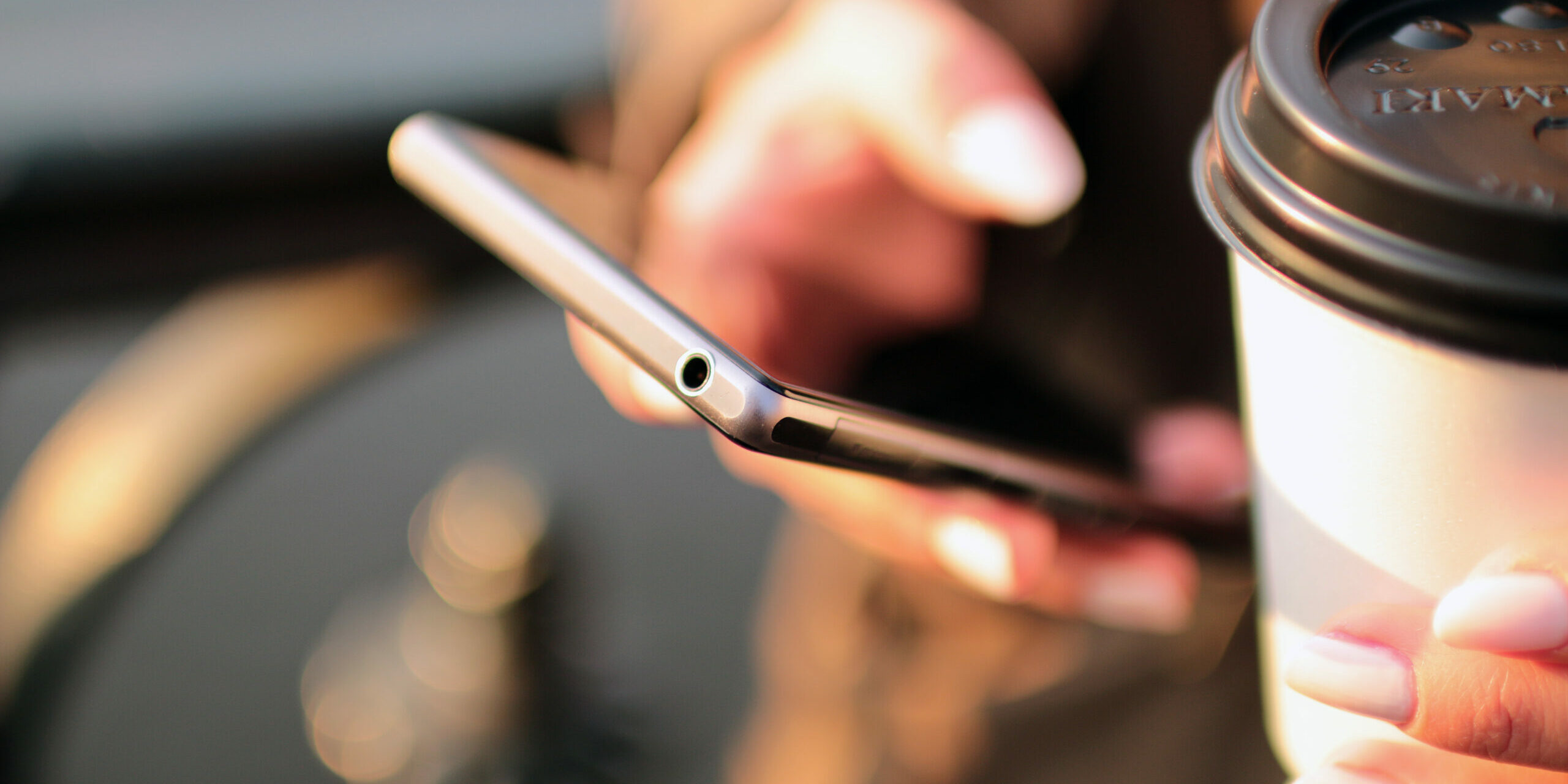 mobile phone in hand with coffee