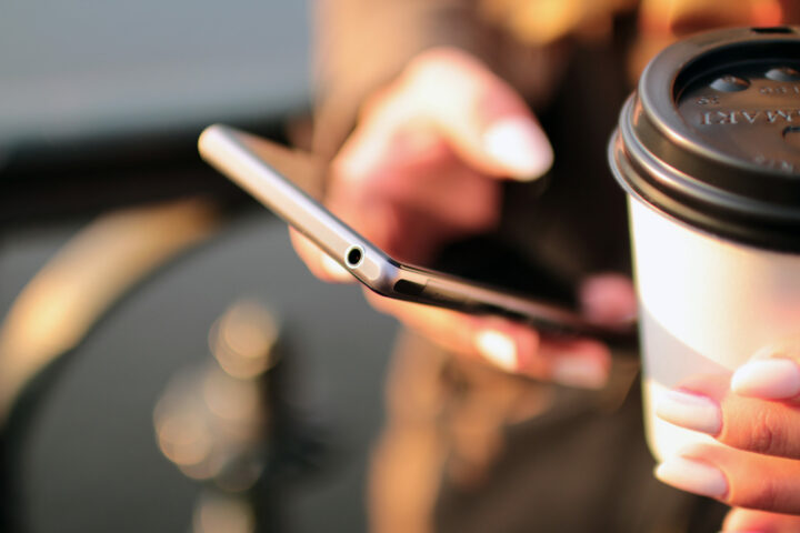 mobile phone in hand with coffee