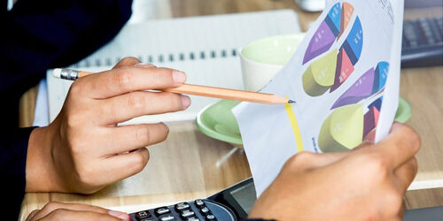 People looking at graphs on paper at a desk