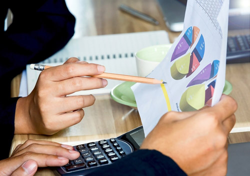 People looking at graphs on paper at a desk