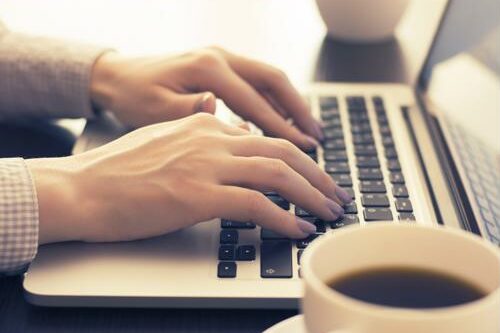 Woman typing on a laptop.