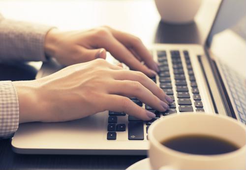 Woman typing on a laptop.