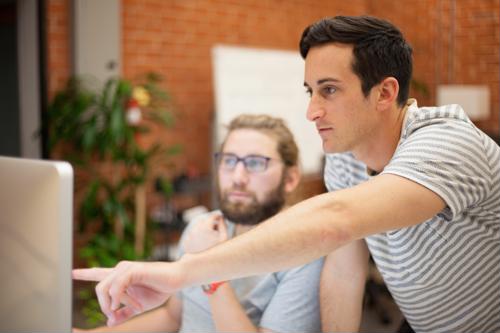 two coworkers looking at a computer