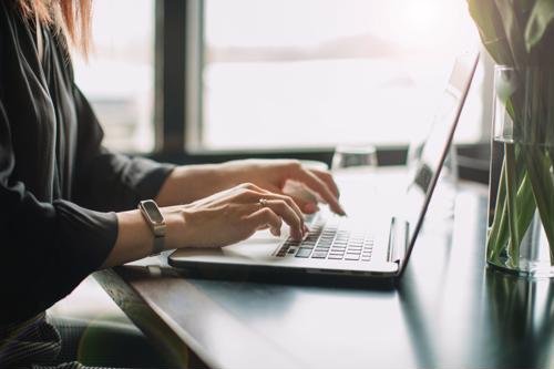 web content manager typing on laptop