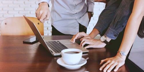 group of employees huddled over computer