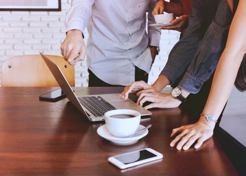 group of employees huddled over computer