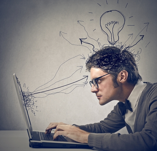 man working on a laptop with cartoon arrows and lightbulb all over his head