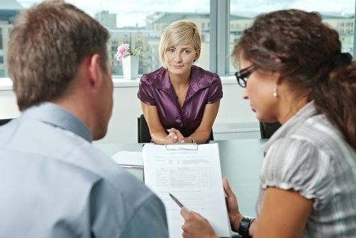 two people interviewing a woman