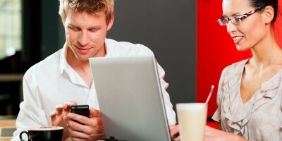 two people working on their electronics in a coffee shop