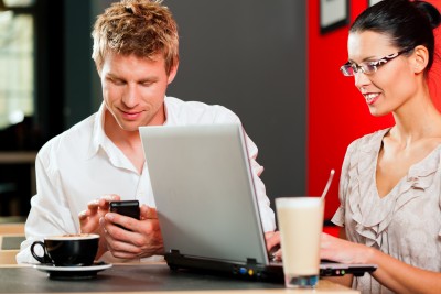 two people working on their electronics in a coffee shop