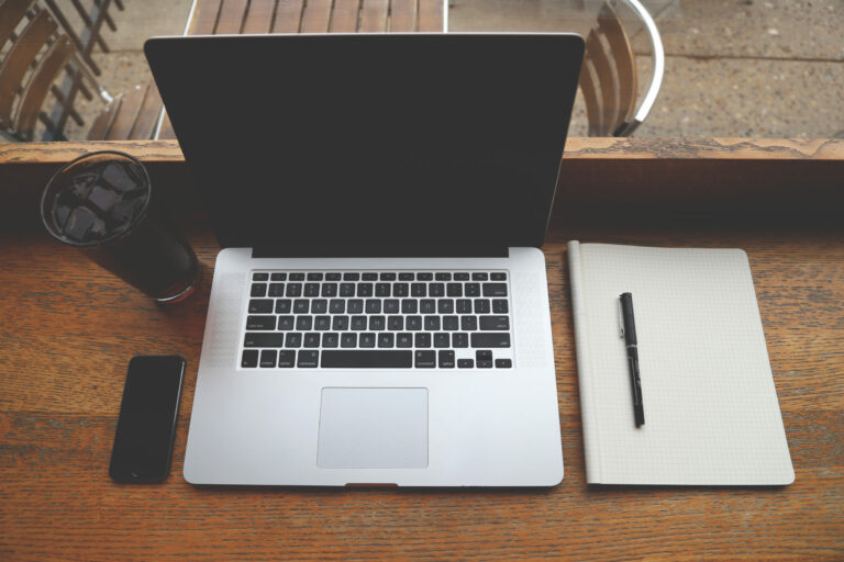 coffee iphone and laptop on wooden desk