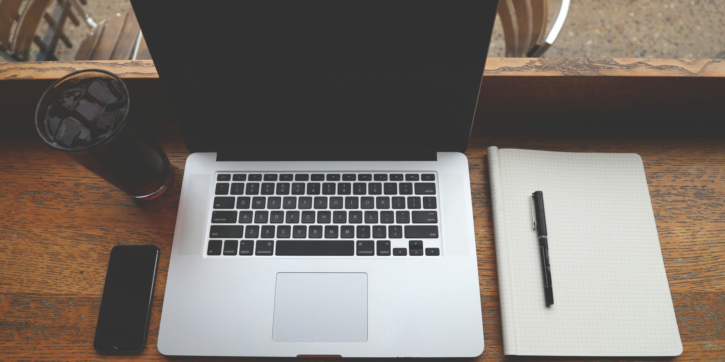 coffee iphone and laptop on wooden desk