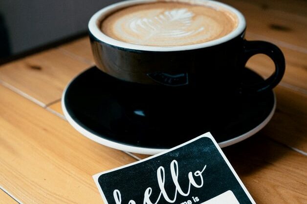 cappuccino in black mug with hello name tag remote onboarding