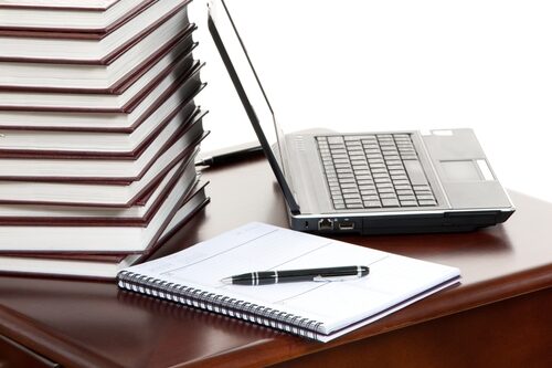 journal sitting at a table with a laptop next to in and a pen on top