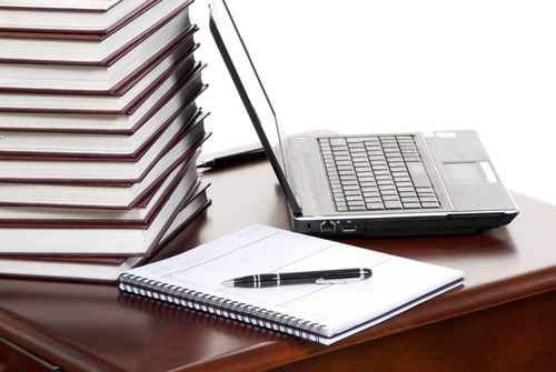 journal sitting at a table with a laptop next to in and a pen on top