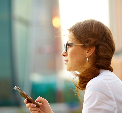 Woman on her phone looking out into the distance