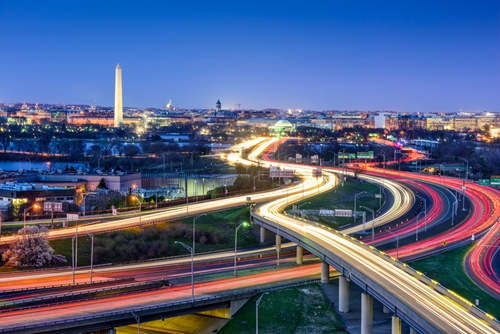 City scape of Washington DC at night with cars driving by