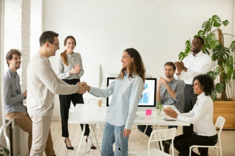 woman employee shakes hands with male colleague