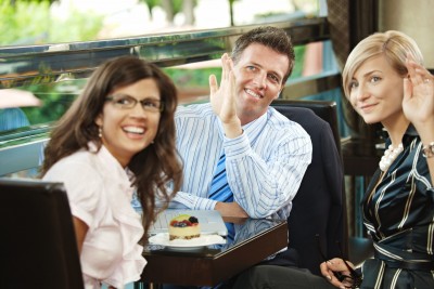 group in a restaurant waving at someone