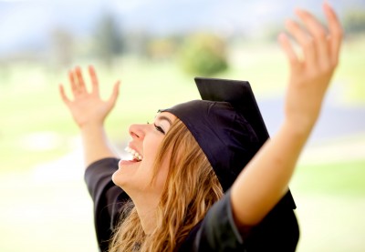 woman celebrating her graduation with her hands in the air