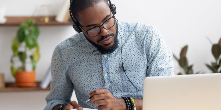 man at computer writing on note pad_job search tips