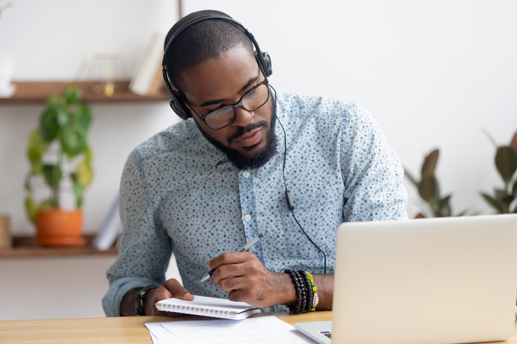 man at computer writing on note pad_job search tips