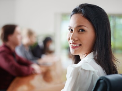 woman in a meeting smiling at the camera