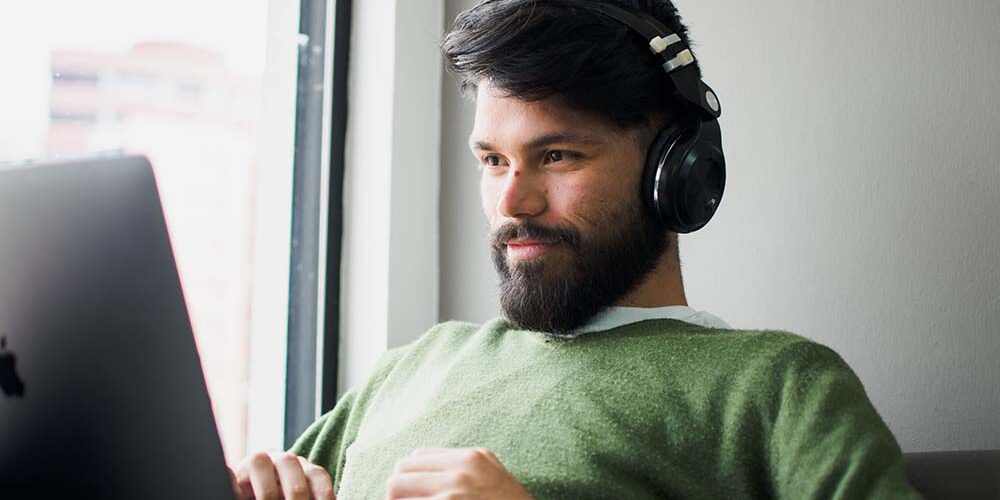 Man On Laptop Listening to Music for Productivity