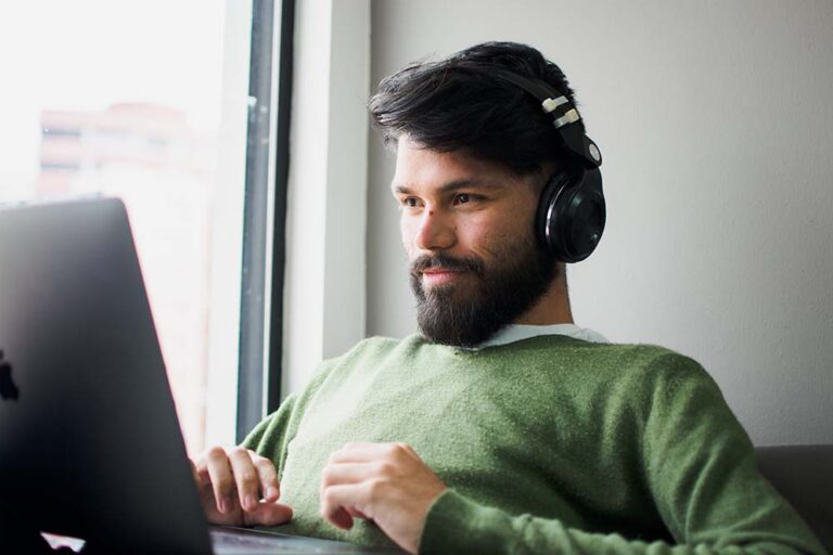Man On Laptop Listening to Music for Productivity