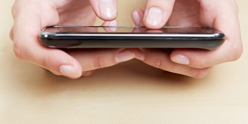 Person holding their phone, close up is on their hands