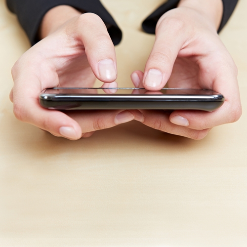 Person holding their phone, close up is on their hands