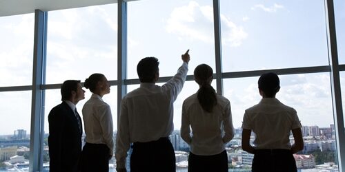 people looking out the window with one man pointing to the sky