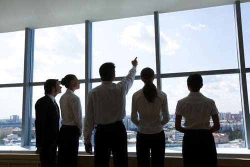 people looking out the window with one man pointing to the sky