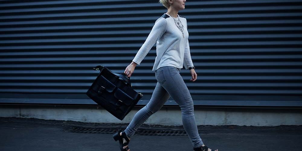 Woman walking down an alley with a brief case