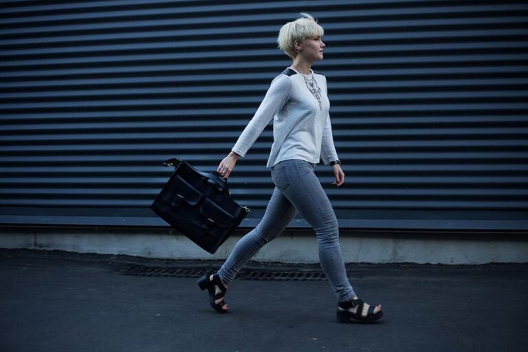 Woman walking down an alley with a brief case