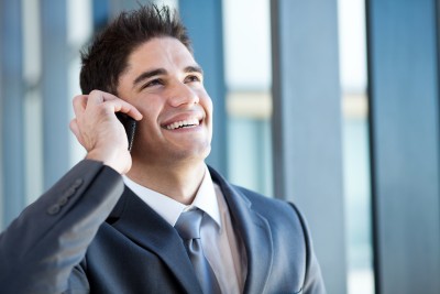 man smiling while he talks on the phone