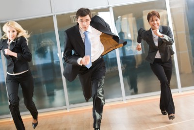 3 business professionals running down a hallway