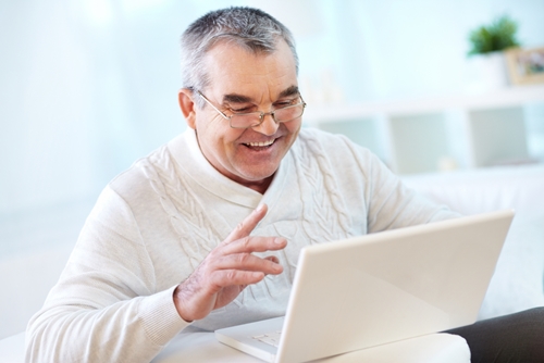 Man smiling as he works on his laptop