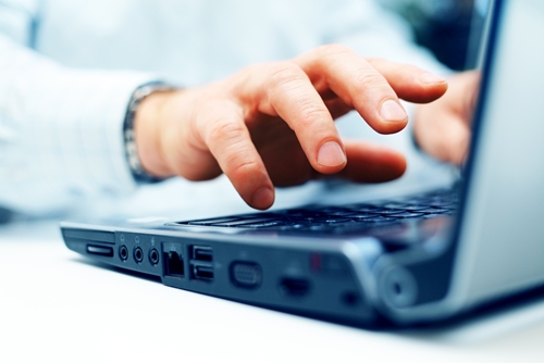 close up of a hand working on a laptop