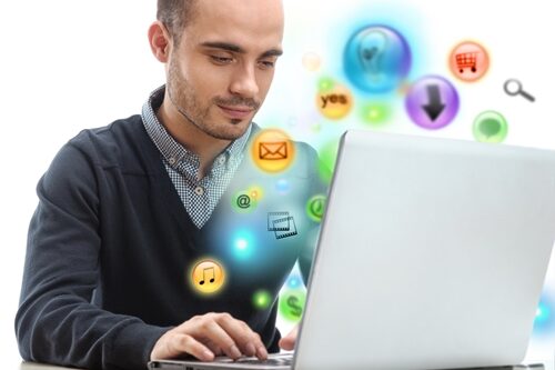 Man working on an old laptop with icon bubble floating around him