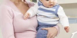 woman working from home as she holds her baby