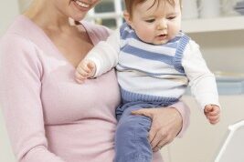 woman working from home as she holds her baby